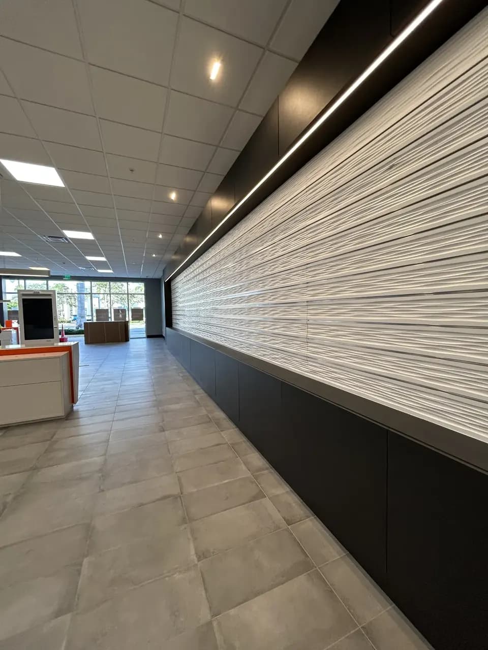 Accessory slat wall and tile floor during finishing work at the Consumer Cellular Fort Myers retail space
