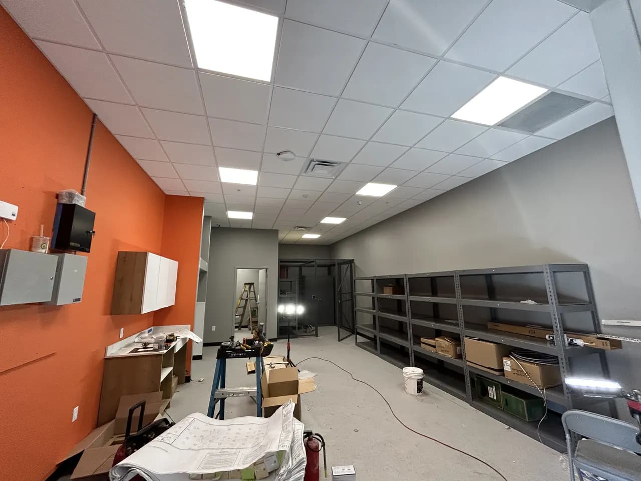 Back-of-house area at Consumer Cellular Fort Myers with shelving, ceiling tiles and materials awaiting installation