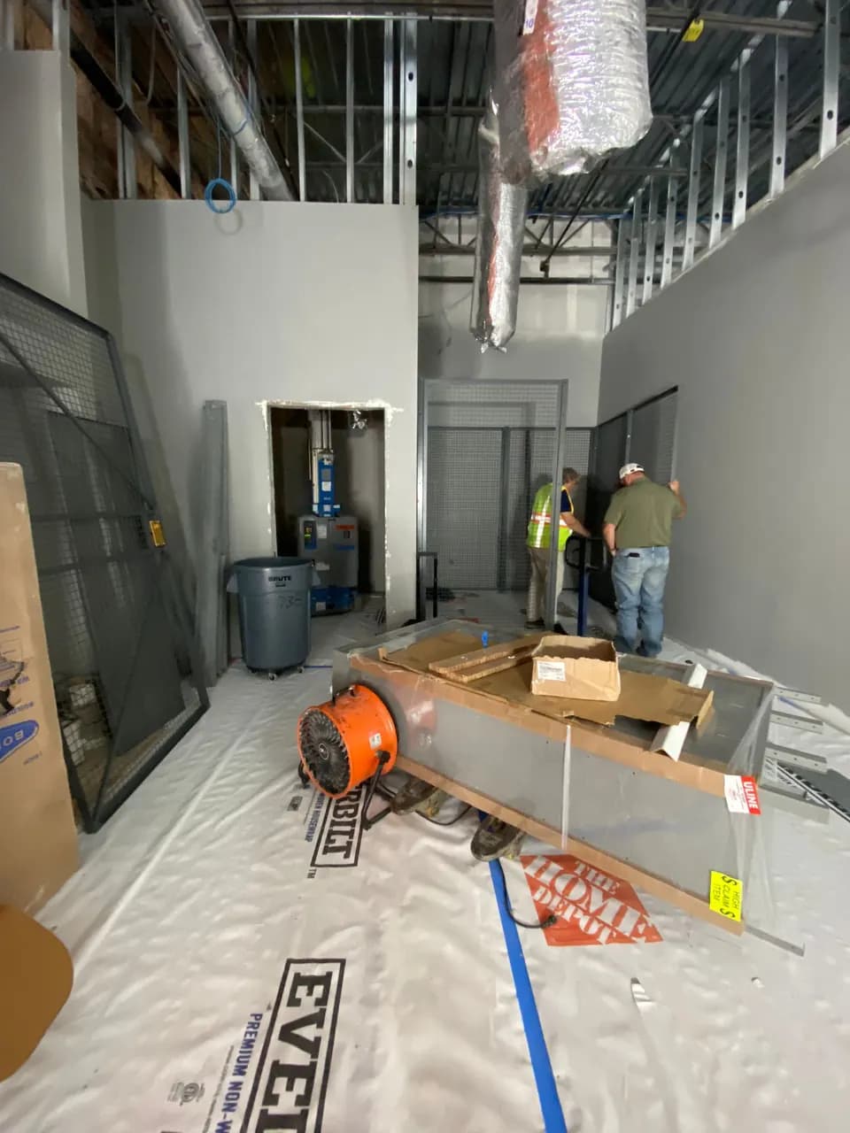 Project team members working in a protected back-room area beneath exposed ductwork at Consumer Cellular Fort Myers