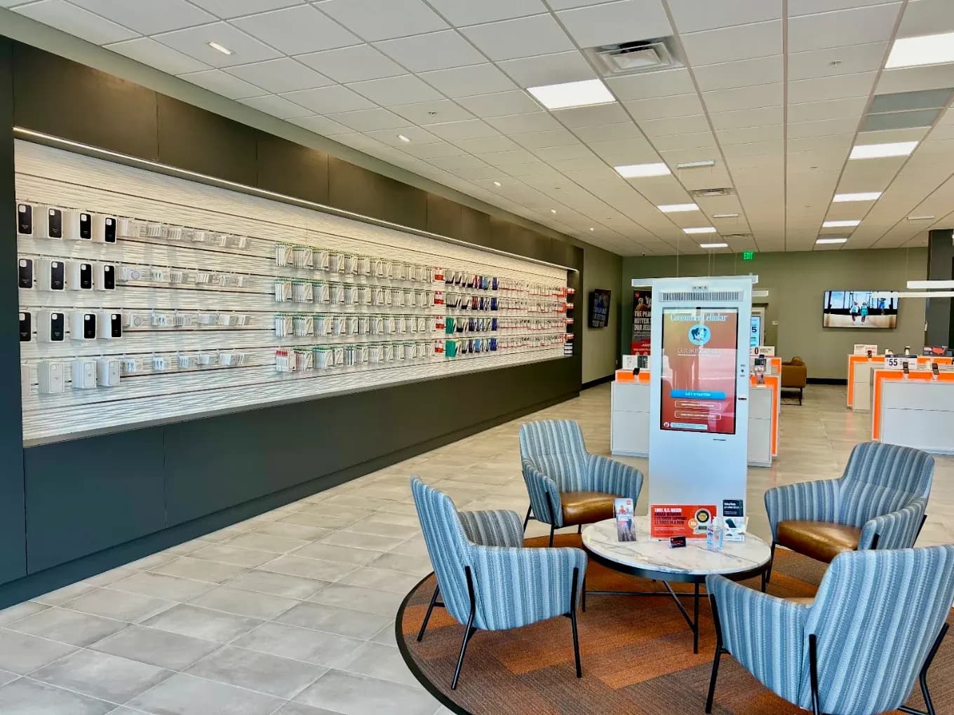 Consumer Cellular Fort Myers accessory display wall beside customer seating and freestanding retail displays