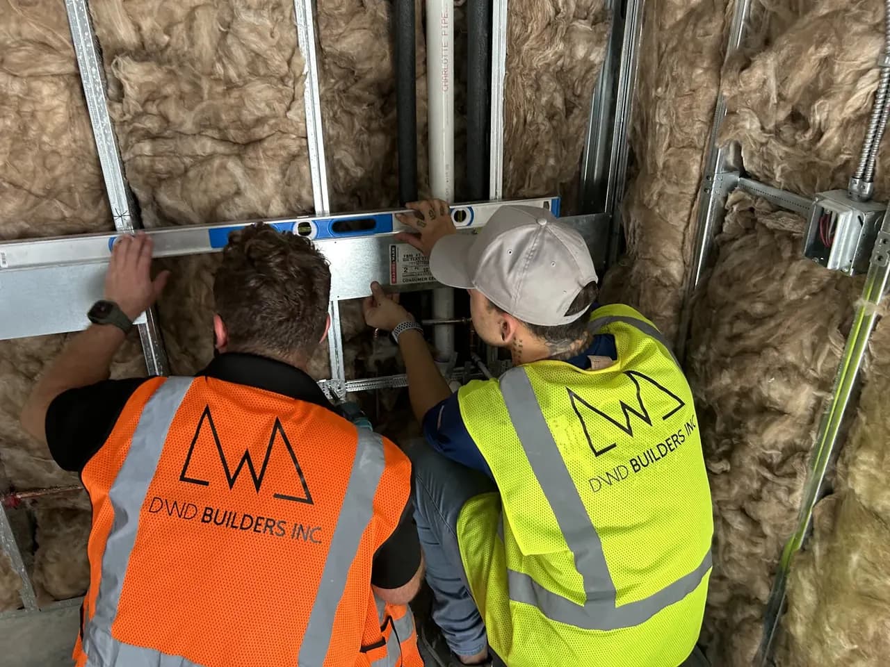 Project team members checking a framed wall with a level during the Consumer Cellular Fort Myers build-out