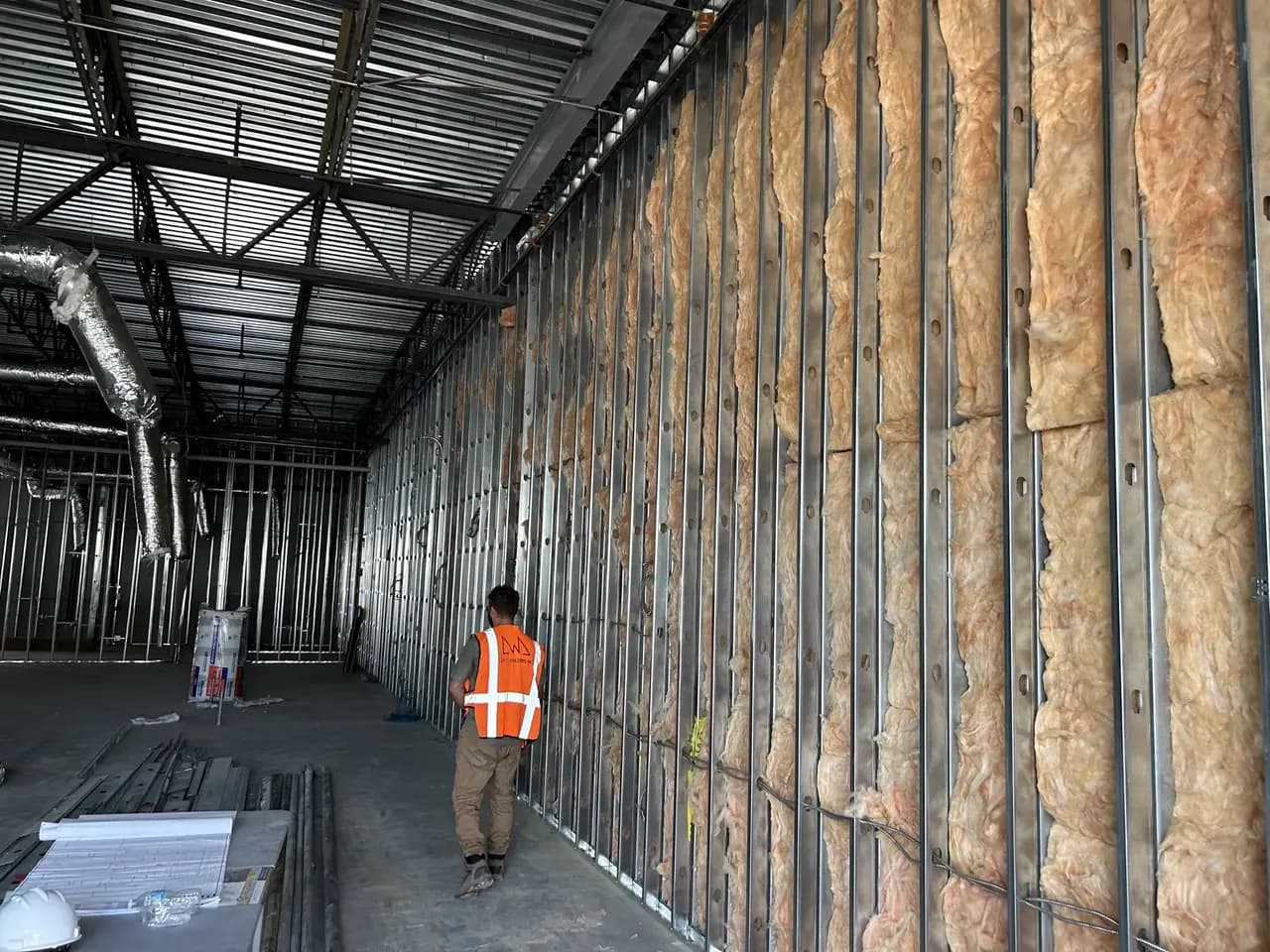 Project team member in the open Consumer Cellular Fort Myers tenant space during framing and rough-in