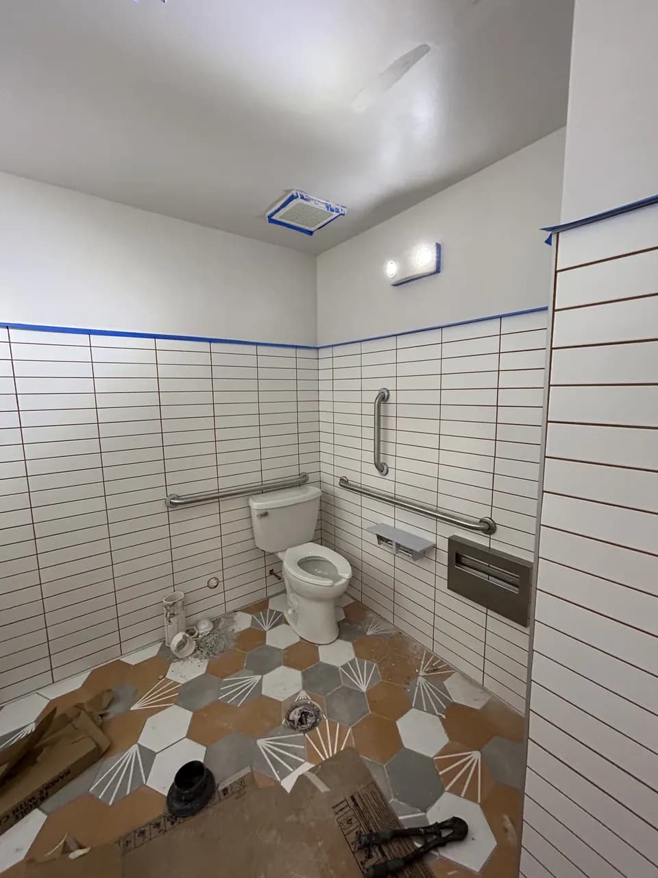 Consumer Cellular Fort Myers restroom with tiled walls, fixtures and construction materials during finishing work