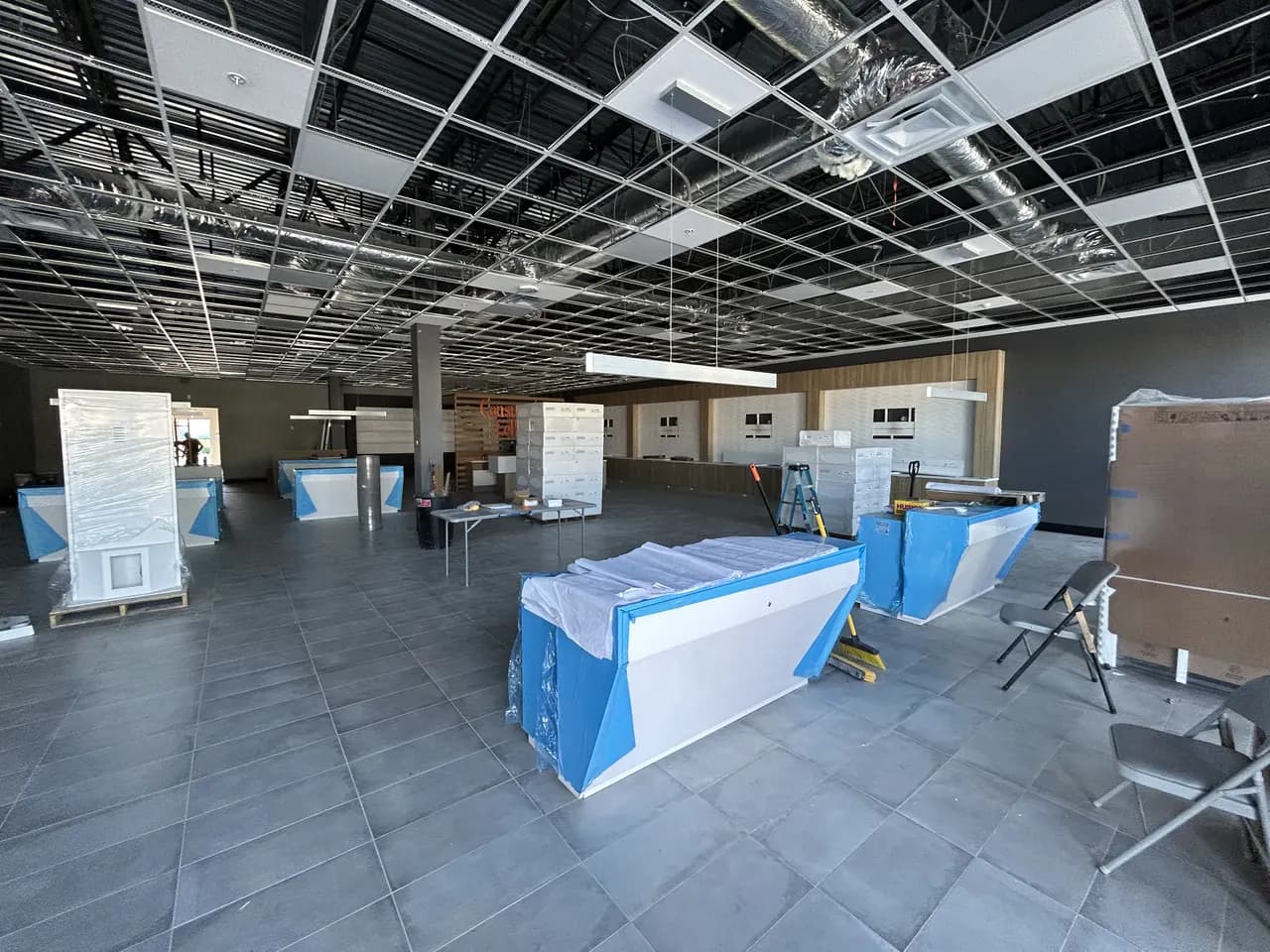 Covered retail display islands and construction materials on the tiled Consumer Cellular Fort Myers sales floor