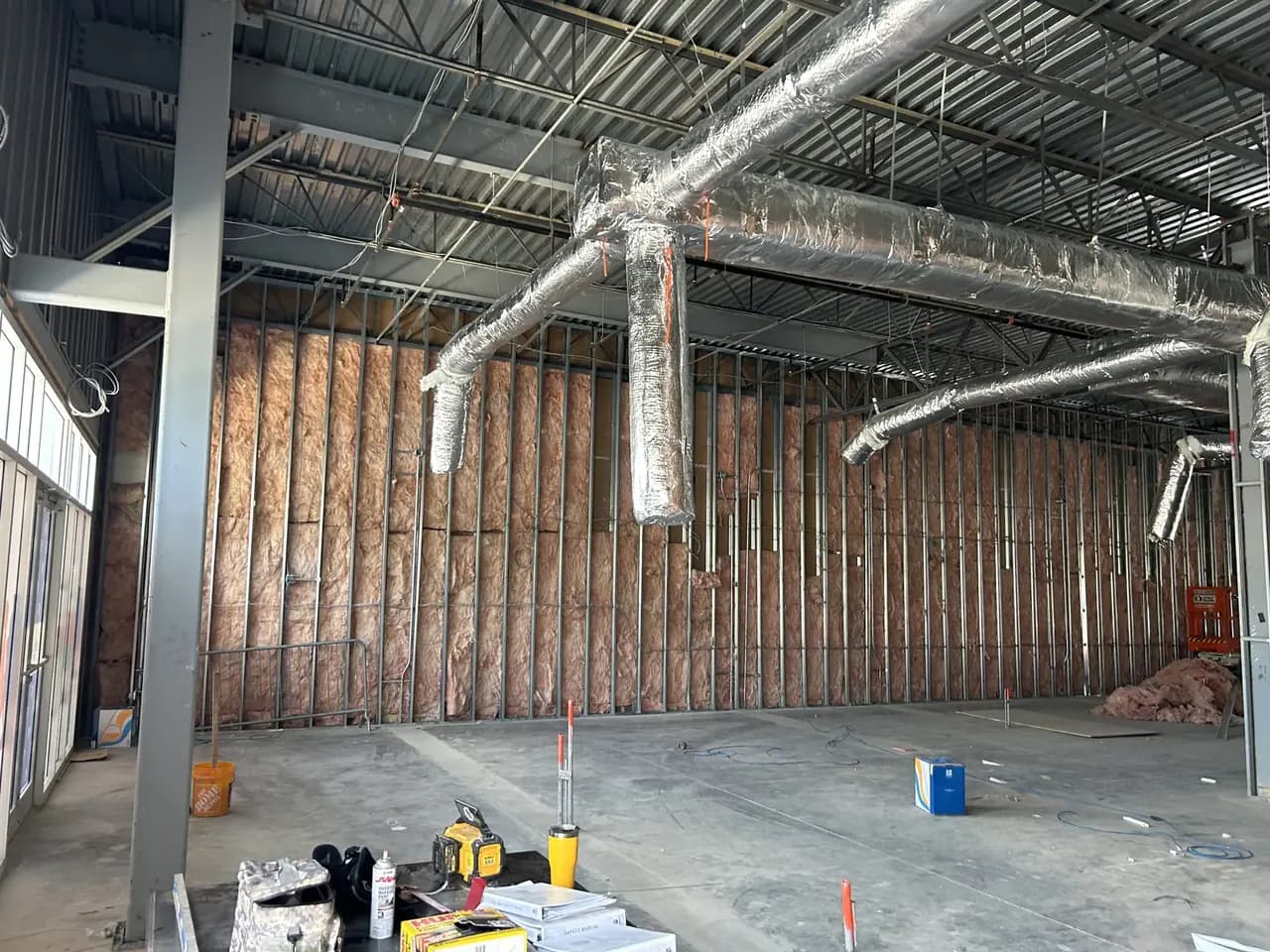 Wide view of framing, wall insulation and exposed ductwork during the Consumer Cellular Fort Myers build-out