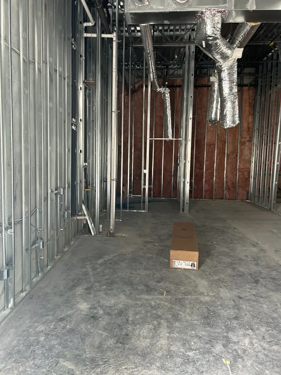 Framed interior corridor with exposed piping and ceiling structure in the Consumer Cellular Fort Myers tenant space