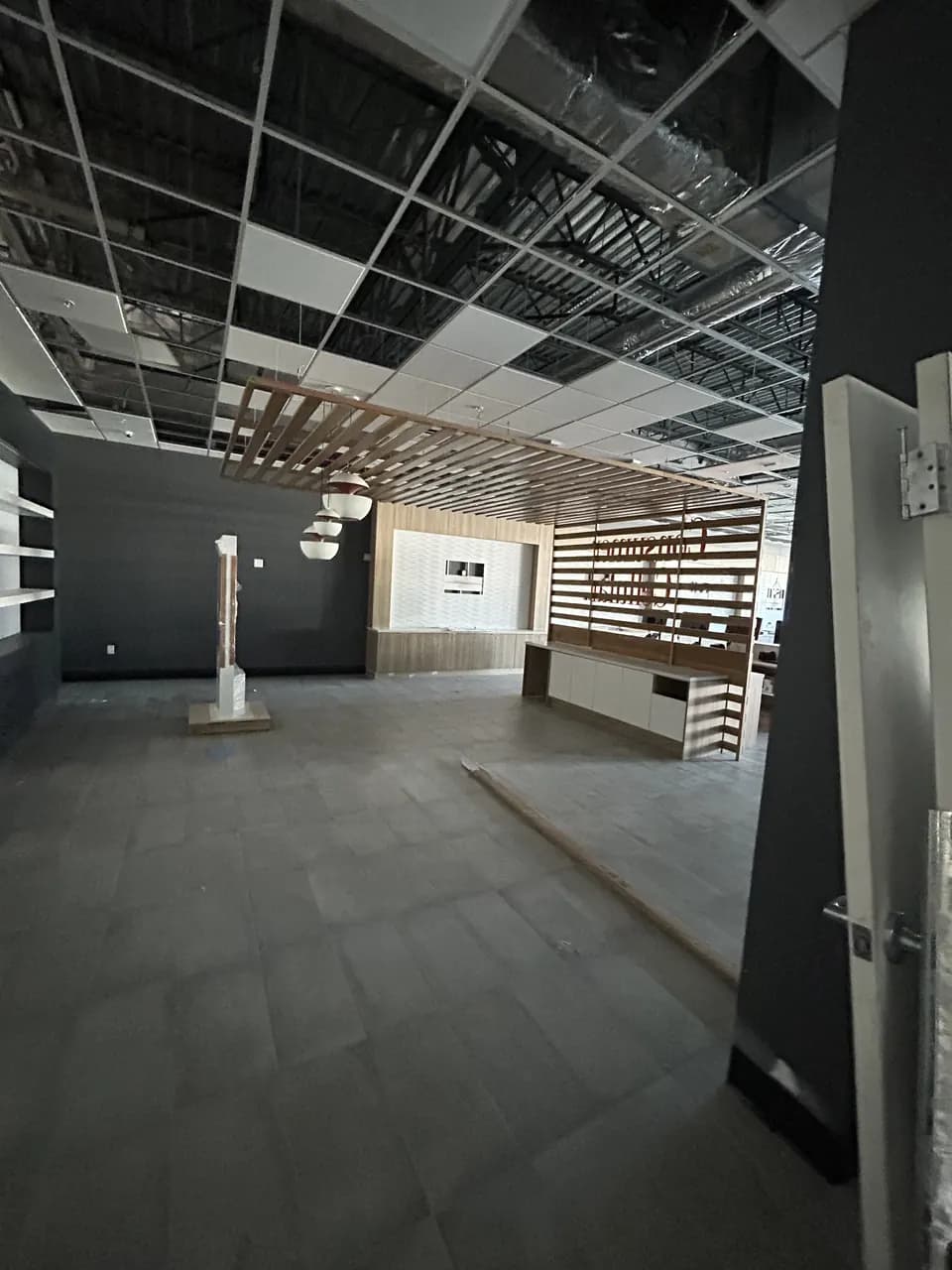 Consumer Cellular Fort Myers sales floor with tiled flooring, display walls and partially installed ceiling tiles