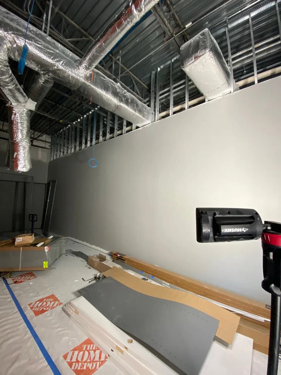 Finished interior wall and protected floor beneath exposed ductwork at Consumer Cellular Fort Myers
