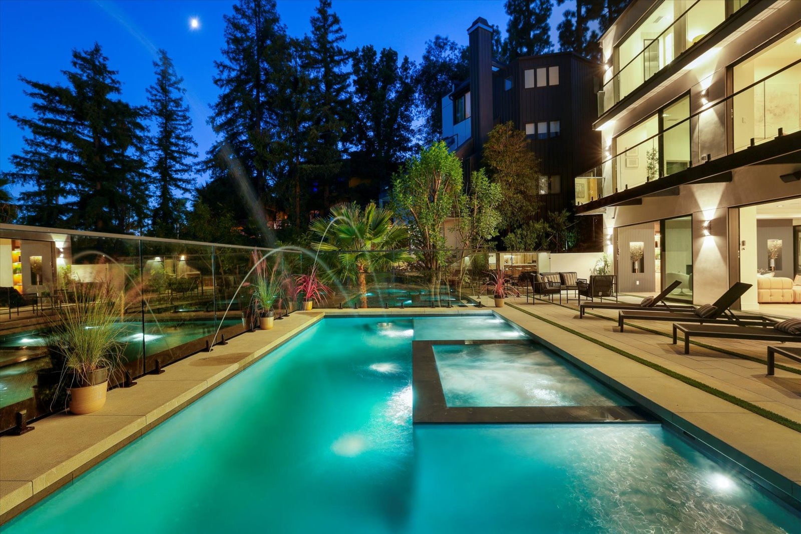 Illuminated pool and rear elevation of a DWD Builders luxury home in Encino, California